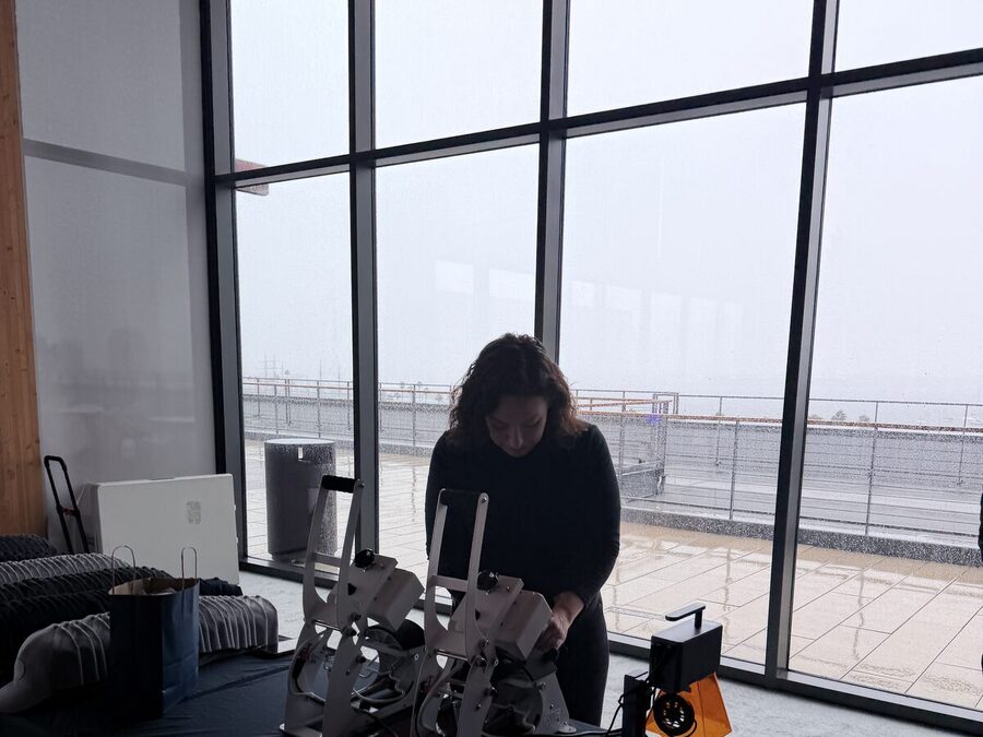 Crew member dialing in heat presses by floor-to-ceiling windows before an event opens